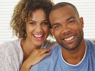 A smiling adult man and woman posing together with a warm expression.